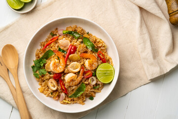 Seafood Tom Yum Fried Rice,Stir fried rice with shrimp and squid with chilli sauce on white plate.Top view