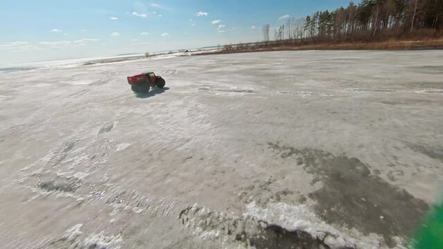 Arctic Rush. A car with large, low-pressure tires. FPV Aerial Drone shot