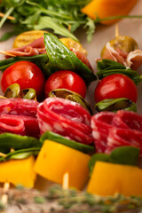 Blurred image of antipastо with salami, cherry tomatoes, cheese and spinach leaves. Quick snack concept