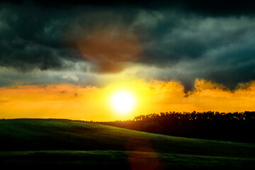 Silence, peace and quiet in the rays of the falling sun. Storm clouds and green hills. A beautiful...