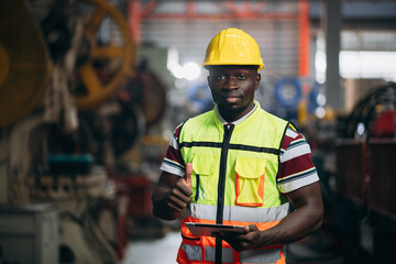 Portrait of industrial worker inspecting and check up machine at factory machines. Technician...