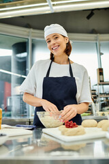 joyful beautiful woman in apron and toque working with dough and smiling at camera, confectionery