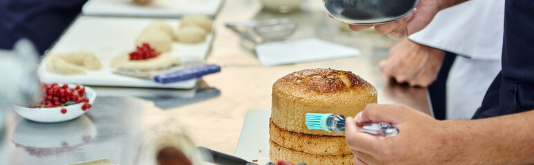 cropped focused view of african american chef using silicone brush near blurred chief cook, banner