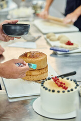 cropped view of african american man using silicone brush next to his colleague, confectionery
