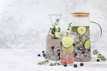 The concept of detox diet and body cleansing. Refreshing homemade lemonade cocktail with fresh cucumbers, blueberries and mint. Fruit juice and ingredients, weight loss concept,