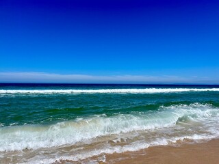 Blue seascape, sandy sea coastline, empty wild beach, pure blue sky, sea horizon