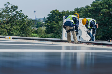 Worker Technicians are working to construct solar panels system on roof. Installing solar...