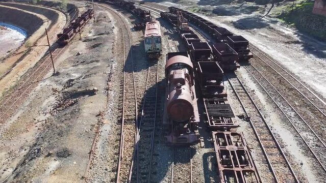 Aerial drone view of an old and rusty steam mining train used for transportation of the copper of  Corta Atalaya mining exploitation. Remains of the old copper mining operation in Minas de Riotinto