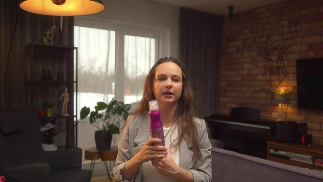 A woman with wet washed hair explains and shows on her head how to properly care for her hair. A tutorial from a hairstylist on hair styling and styling products.