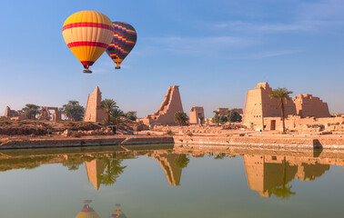 Hot air balloon flying over ancient Temple of Karnak in Luxor - Ruined Thebes Egypt