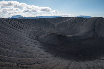 Majestic view of an erupted volcano crater with black sand and scenic landscape in the background,...