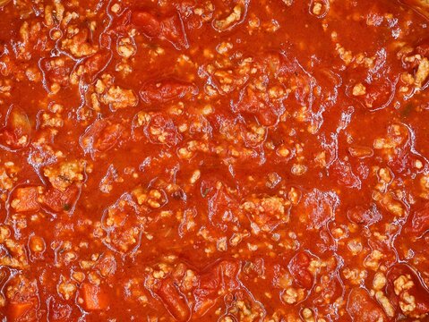 Tasty bolognaise sauce in top view. Tomato sauce with minced meat and vegetables. Food background.