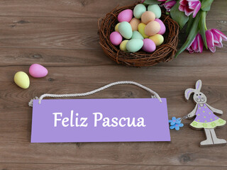 Tarjeta de Pascua: Nido de Pascua con huevos y conejo de Pascua sobre fondo rústico de madera con...
