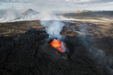 Volcano eruption in Iceland, summit crater, gas expulsion, and molten lava spilling out from a...