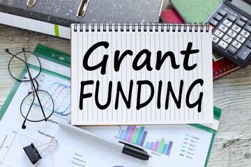Grant funding symbol. financial charts and calculator. text on page