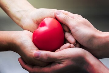 Close up hand giving red heart as heart donor. Valentine day of love concept. Medical ventilator...