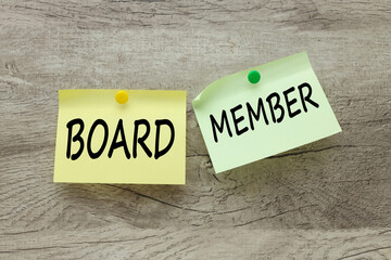 two stickers, green and yellow, riveted to a wooden background. text Board member