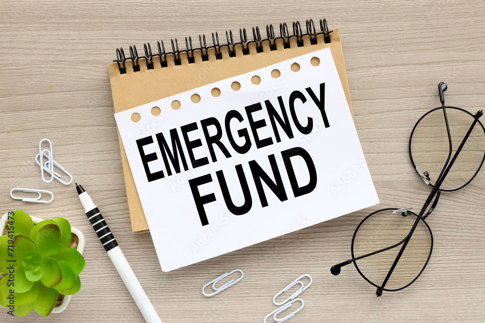 Poster emergency fund : concept of setting money saving goal for rainy day. text on an open notepad. on a w