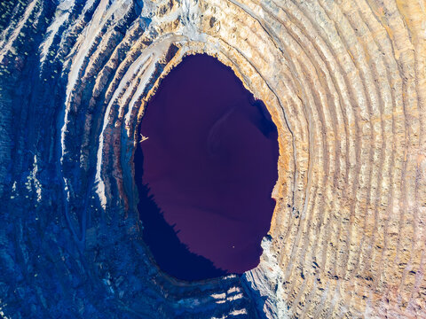 Aerial drone view of Corta Atalaya with mining levels at open mine pit. Deep excavation of pyrite and extraction of minerals of copper and gold in Minas de Riotinto, Huelva, Andalusia, Spain