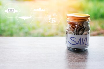 Coins and text SAVE in a glass jar placed on a wooden table. Concept of saving money for...