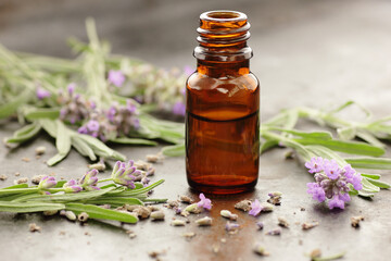 Lavender essential oil or extract in glass bottle with fresh flower and leaf on black background,...