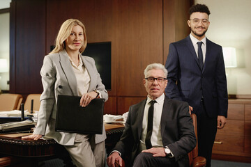 Diverse group of lawyers posing together in office boardroom and smiling at camera
