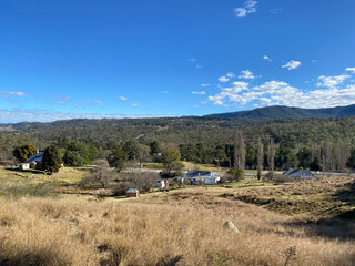 Landscape in the mountains. A few houses on the hills in the distance. Valley with mountain views in autumn.