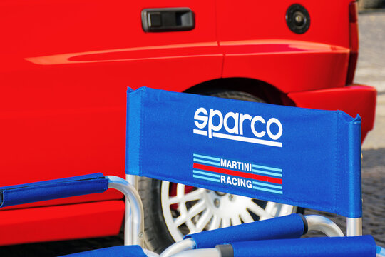 uzhgorod, ukraine - 31 oct 2021: close-up of a blue chair with sparco, martini racig, logo in front a red lancia delta car