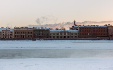 Covered with snow river, residential buildings in background