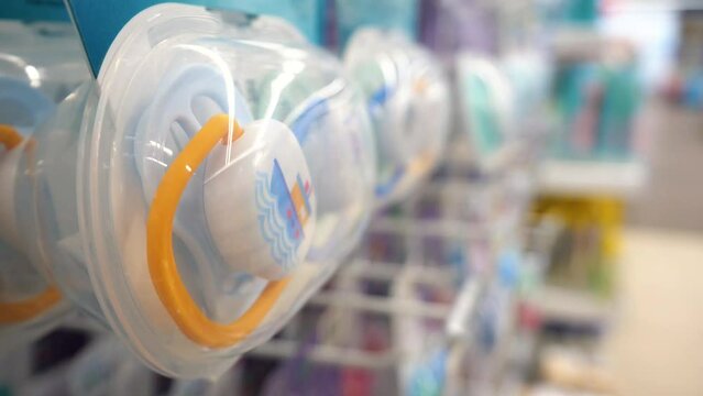 Lots of baby pacifiers. Baby pacifiers on a shelf in a store.