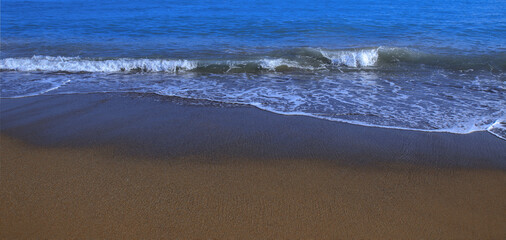 Seascape. Turbulent the sea. Vacation and summer concept. Powerful Ocean blue waves with white foam. Sea wave. Marine nature. Large turquoise sea wave. Sandy beach sea shore with wave and white foam. 