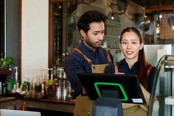 Bearded Indian man wearing overalls Teach him how to use the cash register with his beautiful Asian...