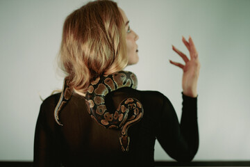 python snake plays with a young blond woman