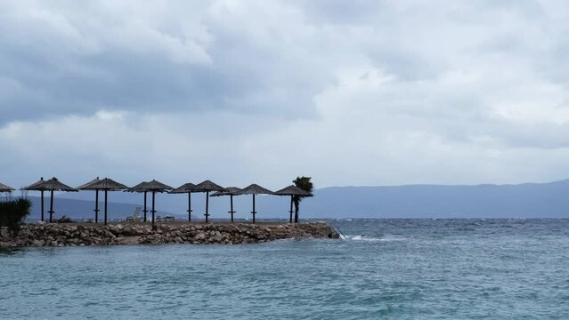 Powerful waves crashing the coast of Njivice, Croatia one day after Storm Ciar&aacute;n smashed into Krk Island. Beautiful disquiet blue sea surface on a rainy day. Cinematic water splashes.