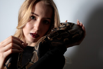 python snake plays with a young blond woman