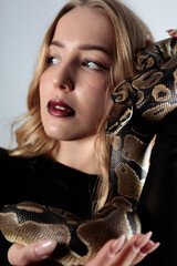 python snake plays with a young blond woman
