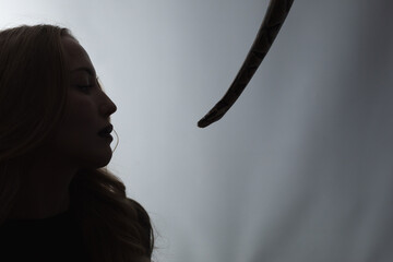 python snake plays with a young blond woman