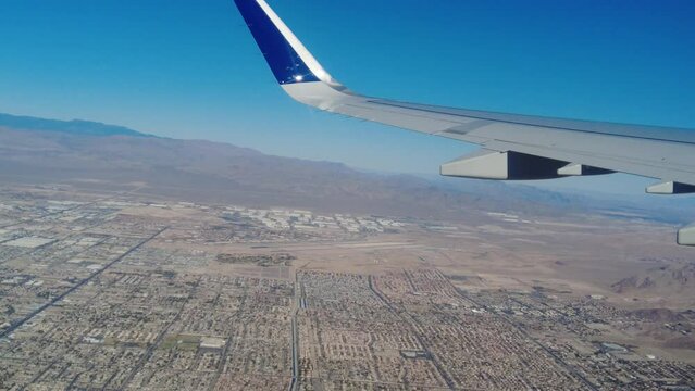 Aircraft close up wing view flying over las vegas city showing nellis air force base us air force in the distance