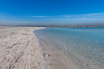 Clear water reflections on shallow sandy beach bottom. UAE Jumeirah beach.