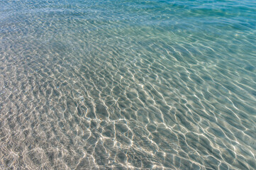 Clear water reflections on shallow sandy beach bottom. UAE Jumeirah beach.