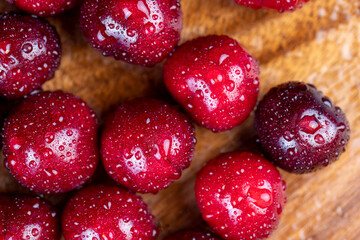 covered with drops of water ripe red cherries on the table