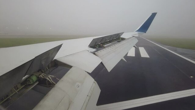 Airplane vacating runway turning onto taxiway driving window seat perspective flaps closing