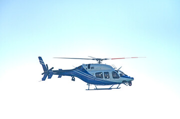 A blue helicopter flying in the sky.