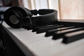 A headphone put atop of piano keys 