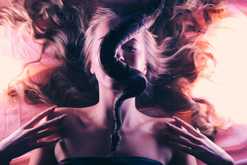 Snake python shooting on blond young woman with light effekts