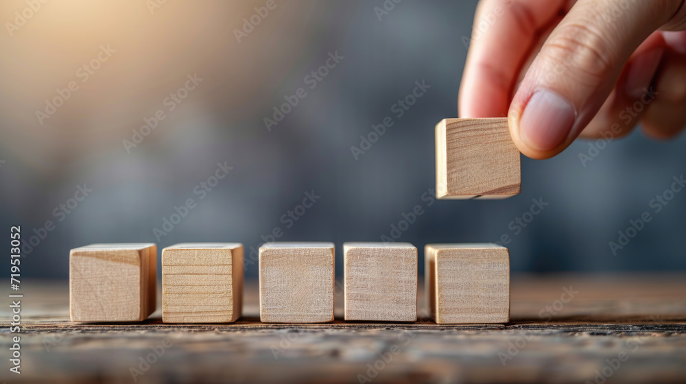 Poster person is seen placing wooden block into row of smaller blocks. this image can be used to illustrate