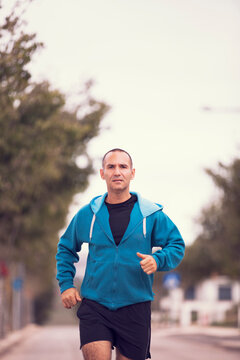 Mature man running, workout and streetching at the city park