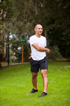 Mature man running, workout and streetching at the city park