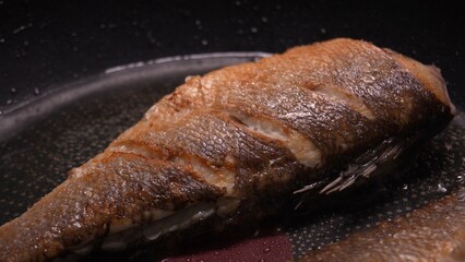 Crispy Seared Fish in Frying Pan. Close-up, shallow dof.