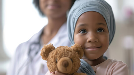 young girl, holding a teddy bear and looking up, presumably at a doctor who is out of focus in the background